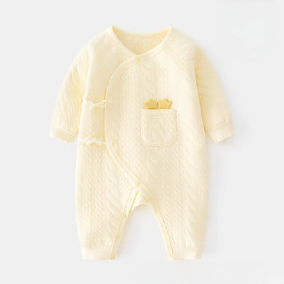 Pale yellow newborn kimono bodysuit made of soft quilted cotton. Features a side-snap wrap design and a front pocket with cute yellow star details.